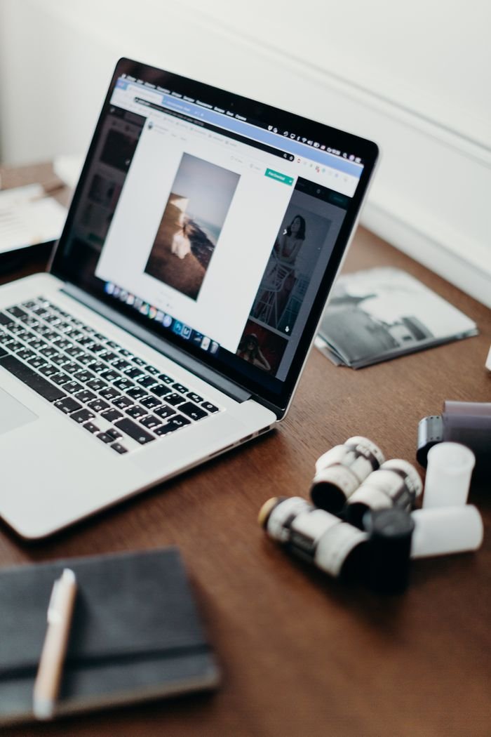 About Close-up of a laptop on a desk with film rolls, showcasing photography workflow.